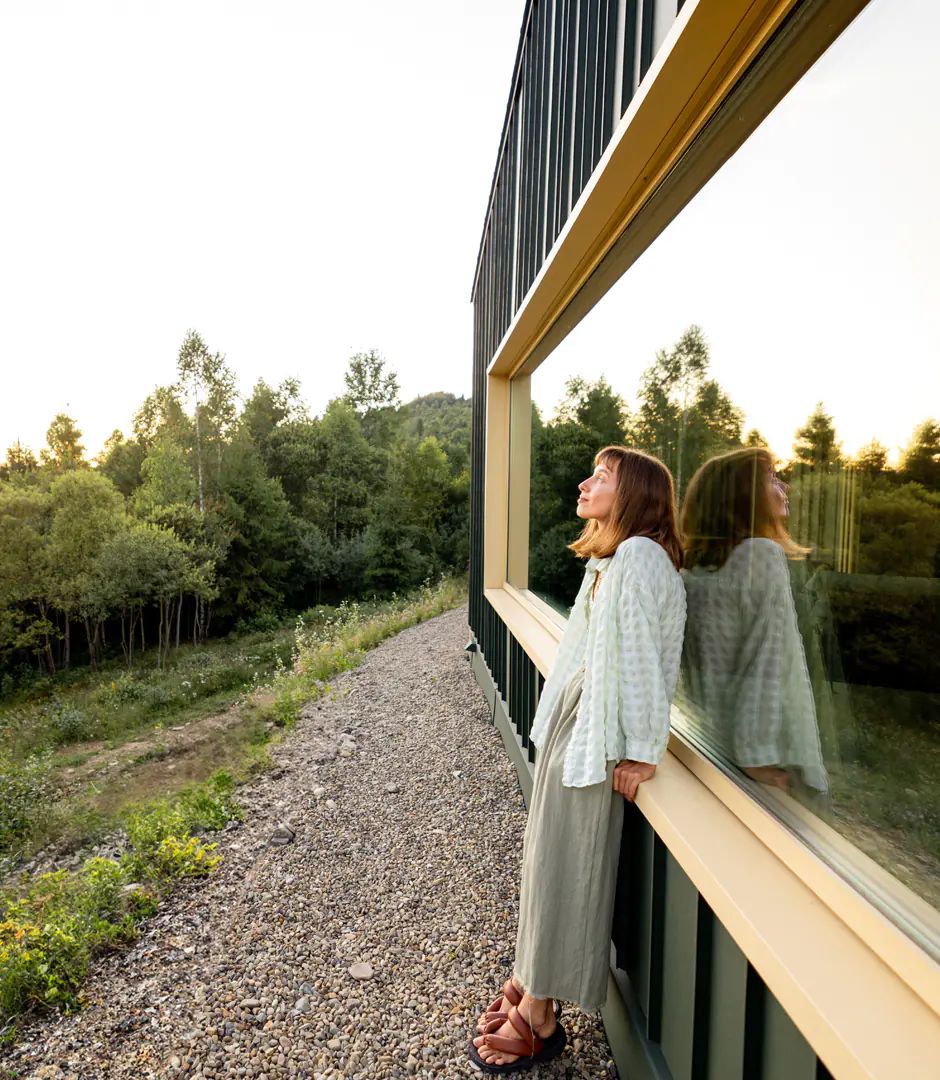 Mujer junto a casa en naturaleza